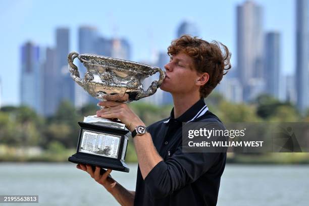Italy's Jannik Sinner poses with the Norman Brookes Challenge Cup trophy following his victory against Germany's Alexander Zverev in the men's...