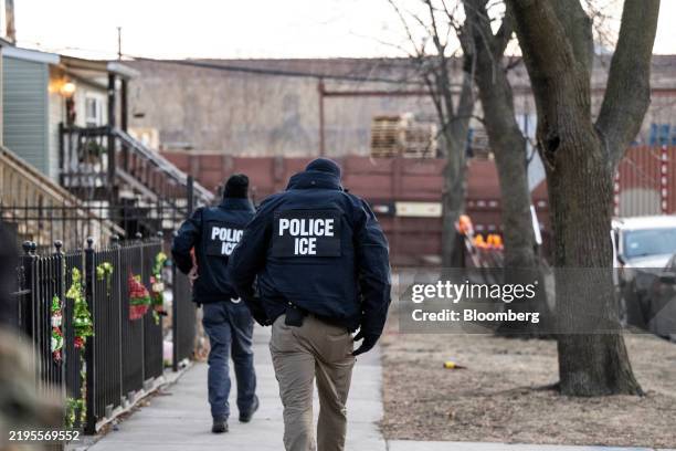 Immigration and Customs Enforcement agents walk down a street during a multi-agency targeted enforcement operation in Chicago, Illinois, US, on...