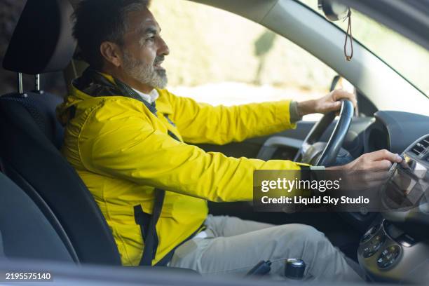 mature man driving car and turning on car radio - car side panel stock pictures, royalty-free photos & images