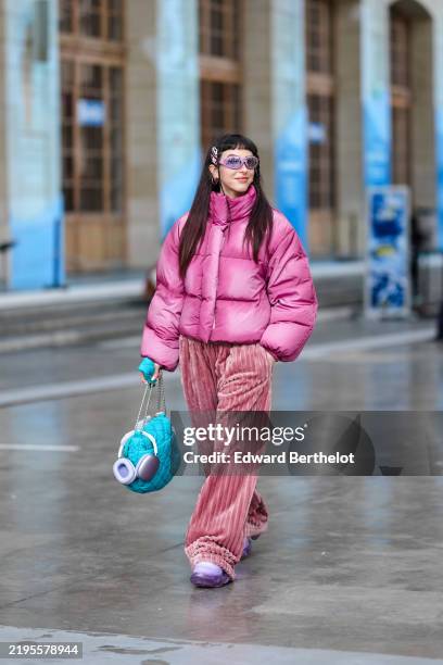 Barbara Malewicz wears light pink sunglasses, hot pink cropped puffer jacket, light pink baggy corduroy pants, light purple sneaker shoes, bright...
