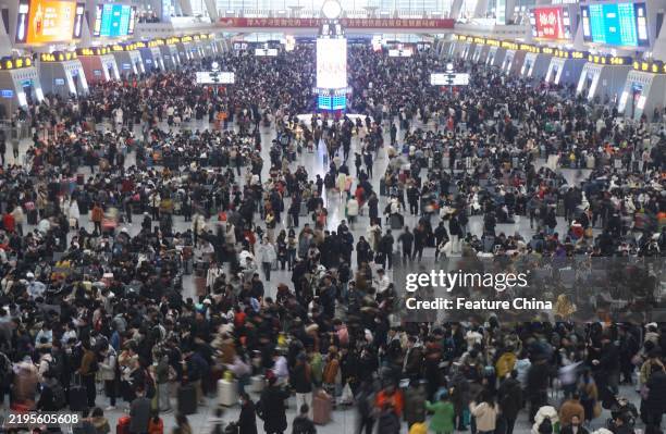 Travelers wait for trains at a railway station in Hangzhou city in east China's Zhejiang province Saturday, Jan. 25, 2025.
