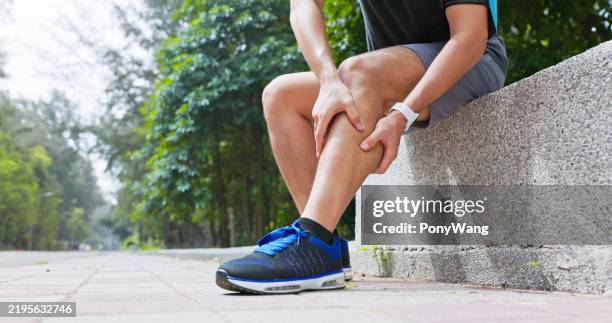 asian man sporting calf cramping - been stockfoto's en -beelden