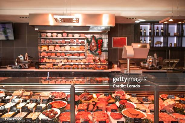 a selection of cut meats in a butcher's shop - butcher stock pictures, royalty-free photos & images