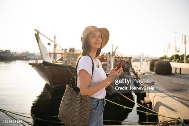 female expatriate on late afternoon walk by dubai wharfage - dubai creek stock pictures, royalty-free photos & images