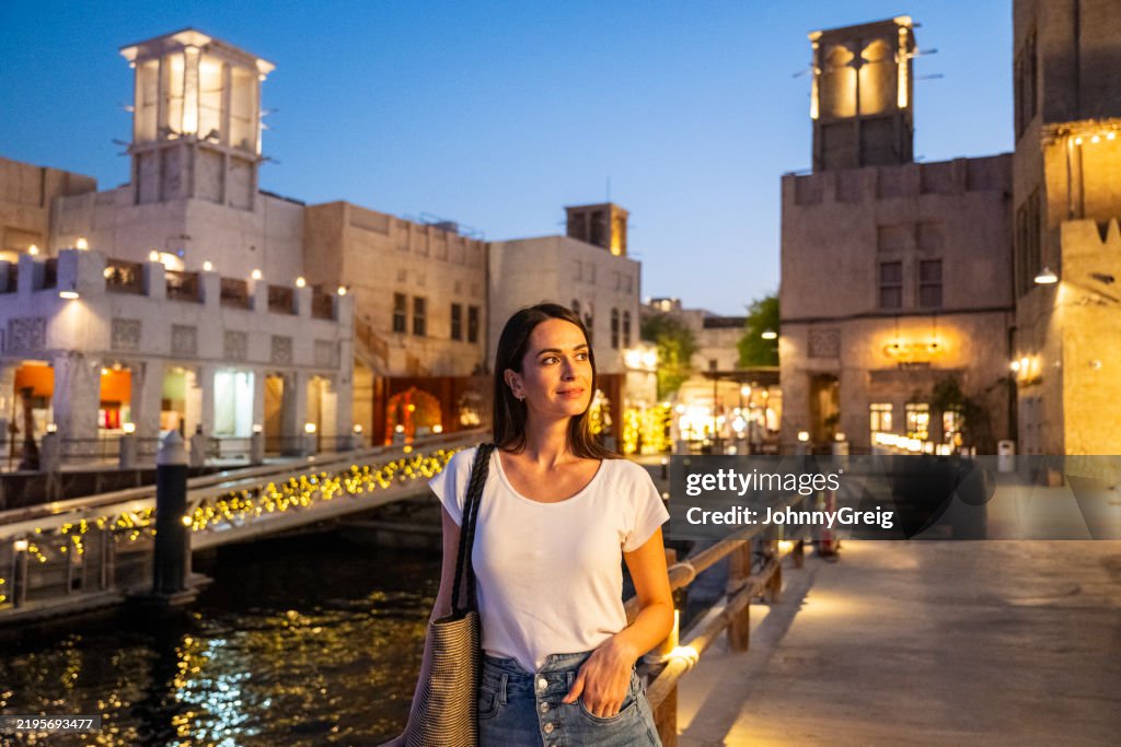 Solo female traveller walking around Al Bastikiya waterfront Dubai at night