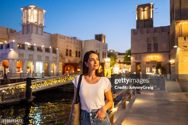 solo female traveller walking around al bastikiya waterfront dubai at night - historic district stock pictures, royalty-free photos & images