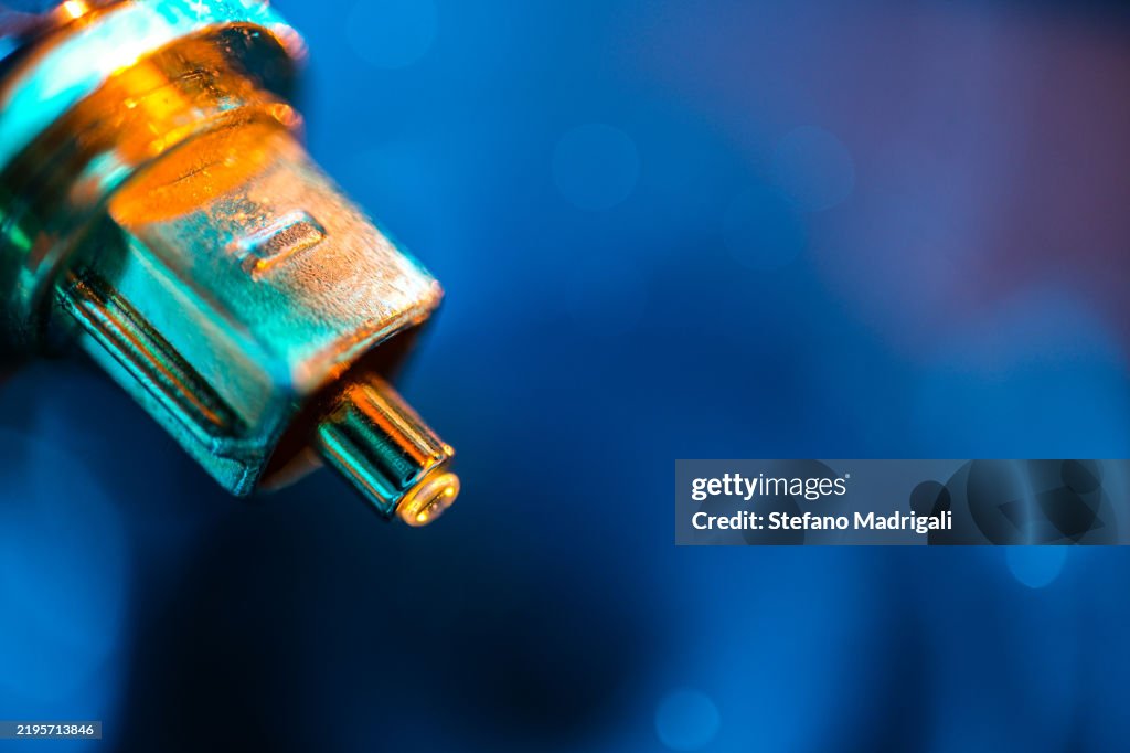 Golden fibre optic coaxial cable, ethereal blue background