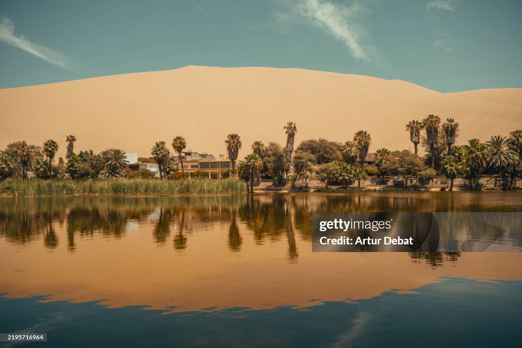 Serene view of the desert oasis lagoon in the Huacachina, Peru