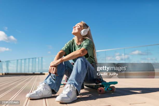 mid adult woman skateboarding - musik bildbanksfoton och bilder