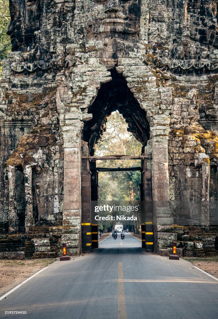 Ancient Stone Gateway of Angkor Wat in Cambodia with Road Passing Through