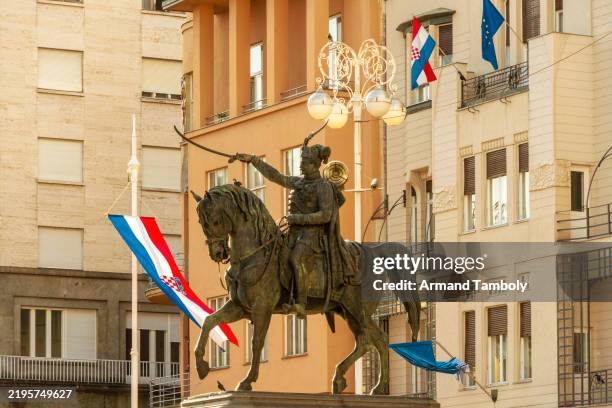 equestrian statue of josip jela?i? in an urban setting against a backdrop of ornate buildings on the square of josip jelacic and a clear sky in the old city of zagreb, croatia - zagreb imagens e fotografias de stock