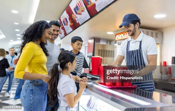 familia en el cine comprando bocadillos en un puesto de comida - puesto de comida rápida fotografías e imágenes de stock