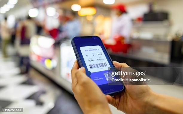 kunde im kino mit seinem ticket auf dem handy - werbeveranstaltung stock-fotos und bilder