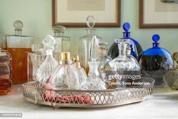 assortment of glass perfume bottles and toiletries in bathroom - perfume atomizer stock pictures, royalty-free photos & images