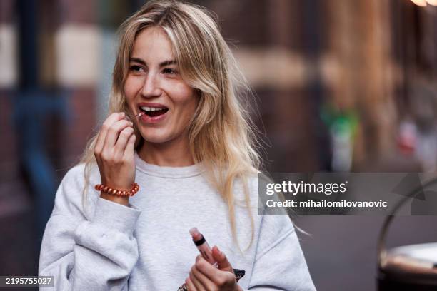 jolie fille mettant du brillant à lèvres - brillant à lèvres photos et images de collection