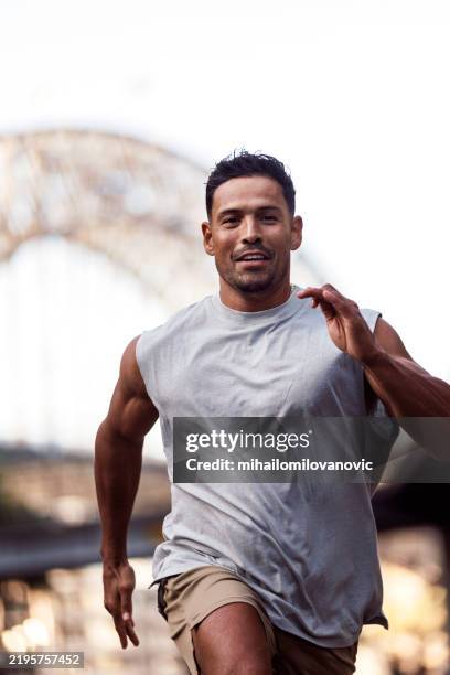 muscular man running - man in white tank top stock pictures, royalty-free photos & images