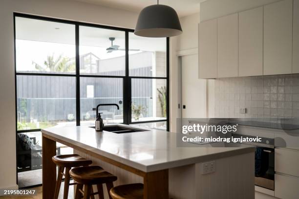 modern kitchen with stools and white cabinets - simple living stock pictures, royalty-free photos & images