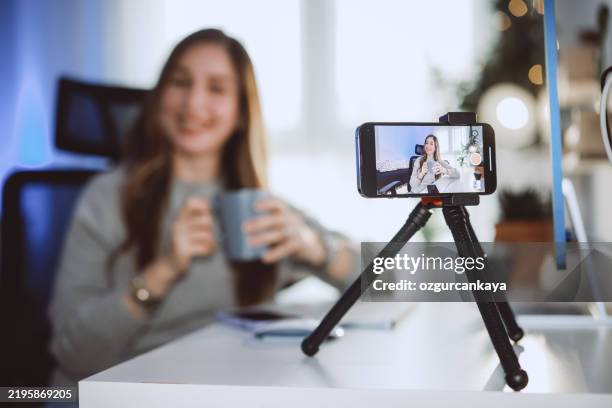 giovane influencer sorridente che fa un post di vlog a casa - social media marketing foto e immagini stock