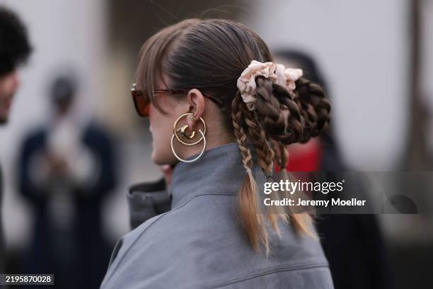 Fashion Week Guest seen wearing a grey leather jacket, golden creols, brown sunglasses, braided plaits with hair bow, outside Ouest Paris...