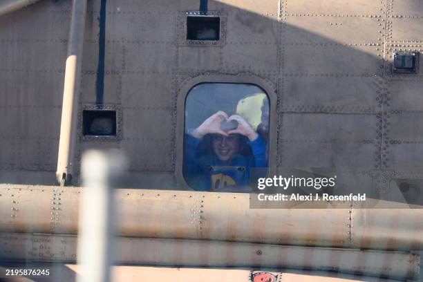 People wave to released hostage Liri Albag as she makes a heart with her hands from the helicopter after arriving at Bellinson hospital on January...