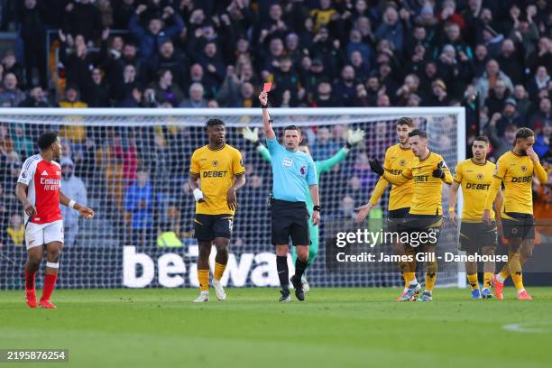 Referee Michael Oliver shows a red card to Myles Lewis-Skelly of Arsenal during the Premier League match between Wolverhampton Wanderers FC and...