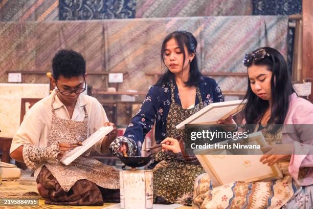 three friends enjoying the batik workshop together - indonesian ethnicity stock pictures, royalty-free photos & images