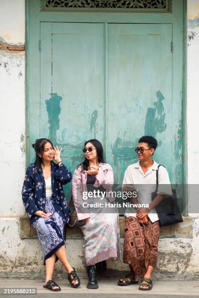 tres amigos posando junto a una ventana de una casa tradicional javanesa - cultura indonesia fotografías e imágenes de stock