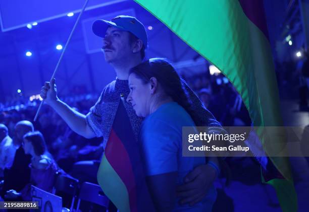 Supporters of the far-right Alternative for Germany political party stand with German flags as they listen to AfD chancellor candidate Alice Weidel...