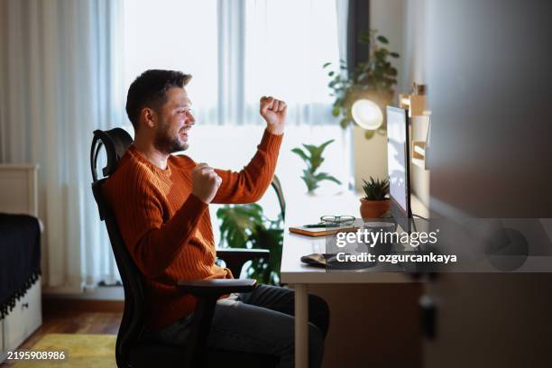 young man using desktop pc at desk in home office - turkish coins stock pictures, royalty-free photos & images