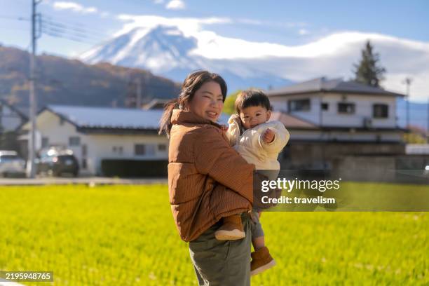 happy asian mother and cute little baby boy toddler relaxing on the backyard homer and enjoying intimate family time together with fuji moutain view background family love concept - prefeitura de shizuoka imagens e fotografias de stock
