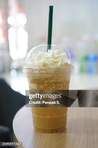 Close up view of ice cubes in cold brewed coffee Cappuccino in plastic cup put on wood desk blurred background, drink beverage Close up view of ice cubes in cold brewed coffee Cappuccino in plastic cup put on wood desk blurred background, drink beverage