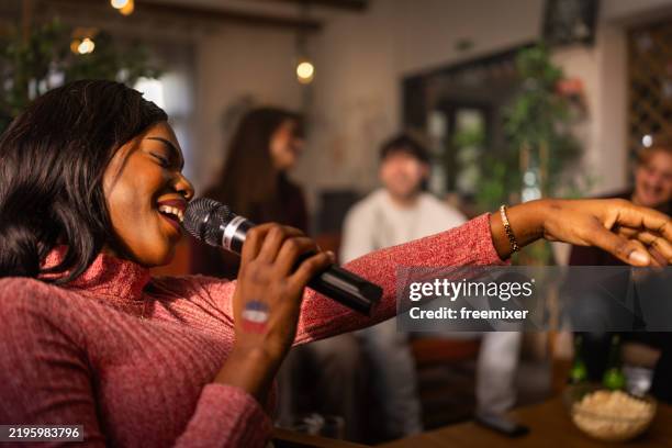 woman singing song in karaoke club - karaoke stock pictures, royalty-free photos & images