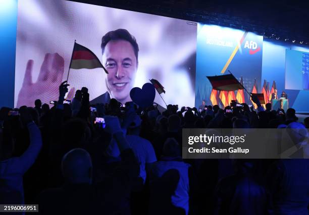 Tech billionaire Elon Musk waves and speaks live via a video transmission during a speech by Alice Weidel, chancellor candidate of the far-right...