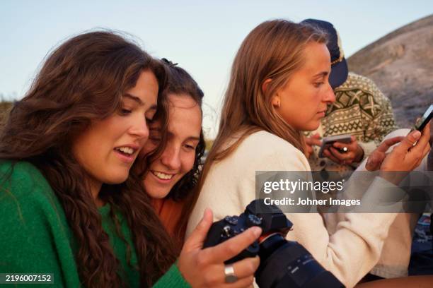 female friends using wireless technologies - slr camera stock pictures, royalty-free photos & images