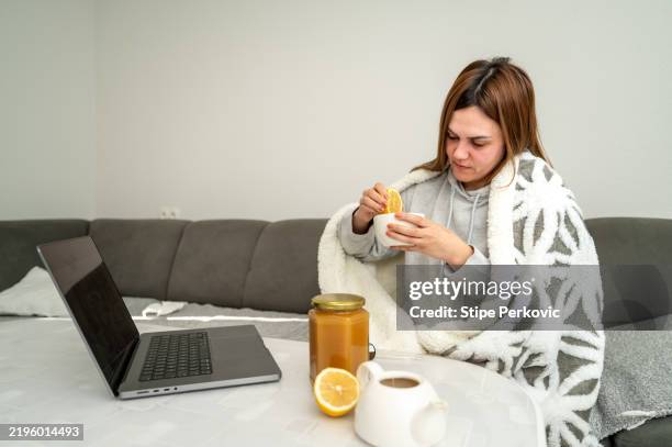 woman resting and using laptop at home - immune system stock pictures, royalty-free photos & images