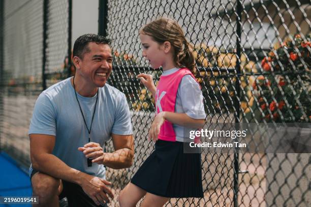 australian coach bonding to his daughter, young netball team player goal keeper during practice - pep talk stock pictures, royalty-free photos & images