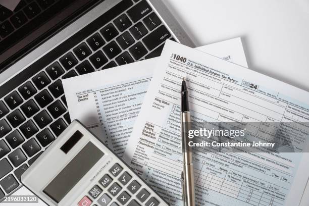 1040 tax form with laptop and calculator - skatt bildbanksfoton och bilder