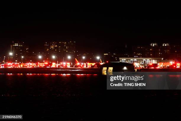 Lights from emergency vehicles are seen at Reagan National Airport in Washington, DC, after an air crash near the Potomac River on January 29, 2025....
