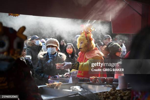 Man dressed as a Monkey King serves snack food to customers at a temple fair on the second day of the Lunar New Year of the Snake in Beijing on...