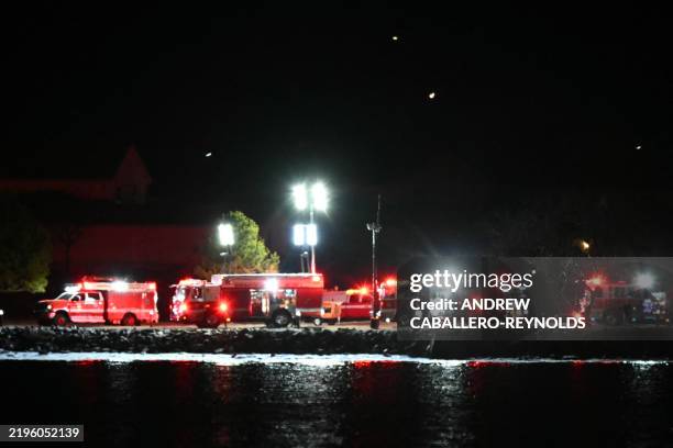 Emergency vehicles and rescue crews gather along the Potomac River near Reagan National Airport after an air crash near Washington, DC, on January...