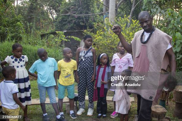 Storytellers tell stories to children by an extinguished fire in Yaounde, Cameroon on January 24, 2025. Storytellers, who convey the cultural...