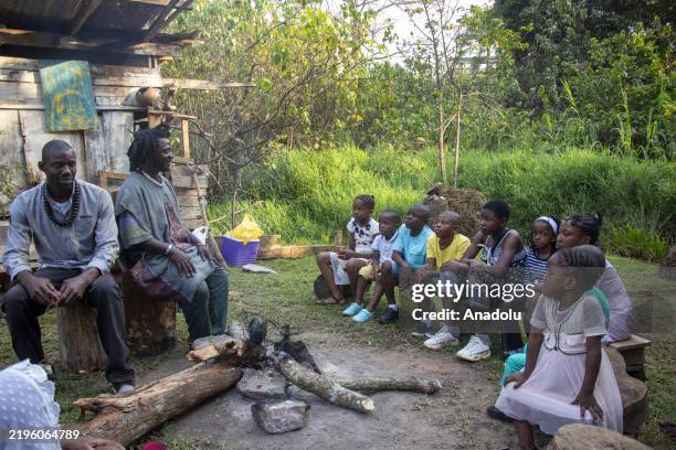 Storytellers tell stories to children by an extinguished fire in Yaounde, Cameroon on January 24, 2025. Storytellers, who convey the cultural...