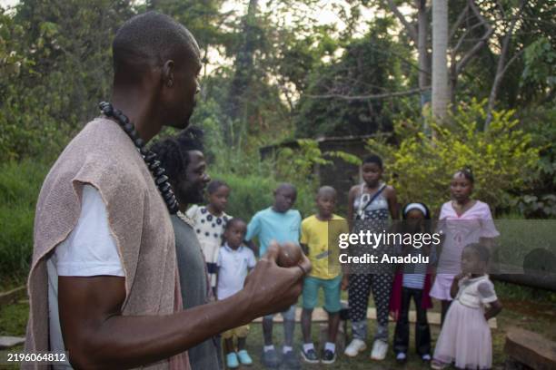 Storytellers tell stories to children by an extinguished fire in Yaounde, Cameroon on January 24, 2025. Storytellers, who convey the cultural...