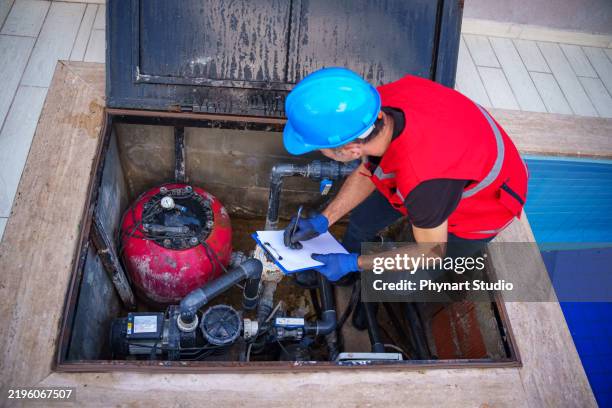 homme homme chargé de l’entretien vérifiant et réparant les tuyaux et les machines de pompage d’eau - pompe à eau photos et images de collection