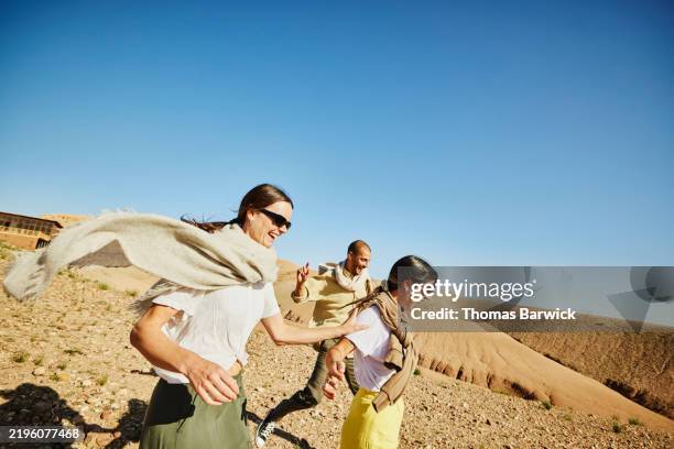 medium wide shot friends exploring desert during stay at luxury camp - reisbestemmingen stockfoto's en -beelden