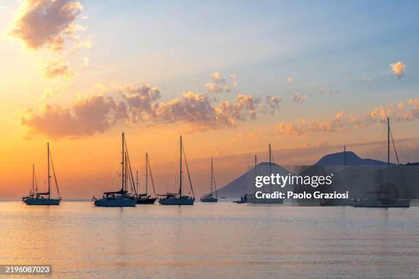 barche a vela ancorate nella baia al tramonto, sicilia, italia - sicilia foto e immagini stock