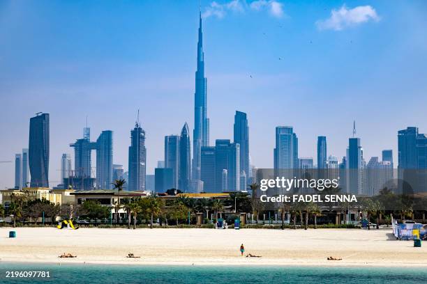 Burj Khalifa, the world's tallest building, adorns the Dubai skyline as people sunbathe on Jumerah beach, on January 30, 2025.