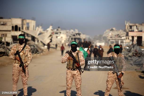 Palestinian Hamas fighters stand guard near the family home of slain Hamas leader Yahya Sinwar, where the militant group prepares to hand over...