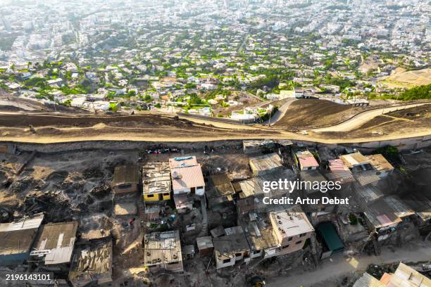 aerial urban view of the wall of shame separating the poverty versus wealth in lima - armoede stockfoto's en -beelden