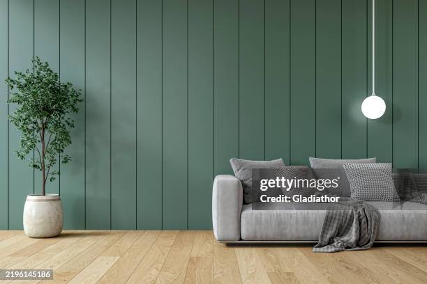 modern interior: a living room with a gray sofa, deep green paneled accent wall background and decoration - scandinavian culture stock pictures, royalty-free photos & images